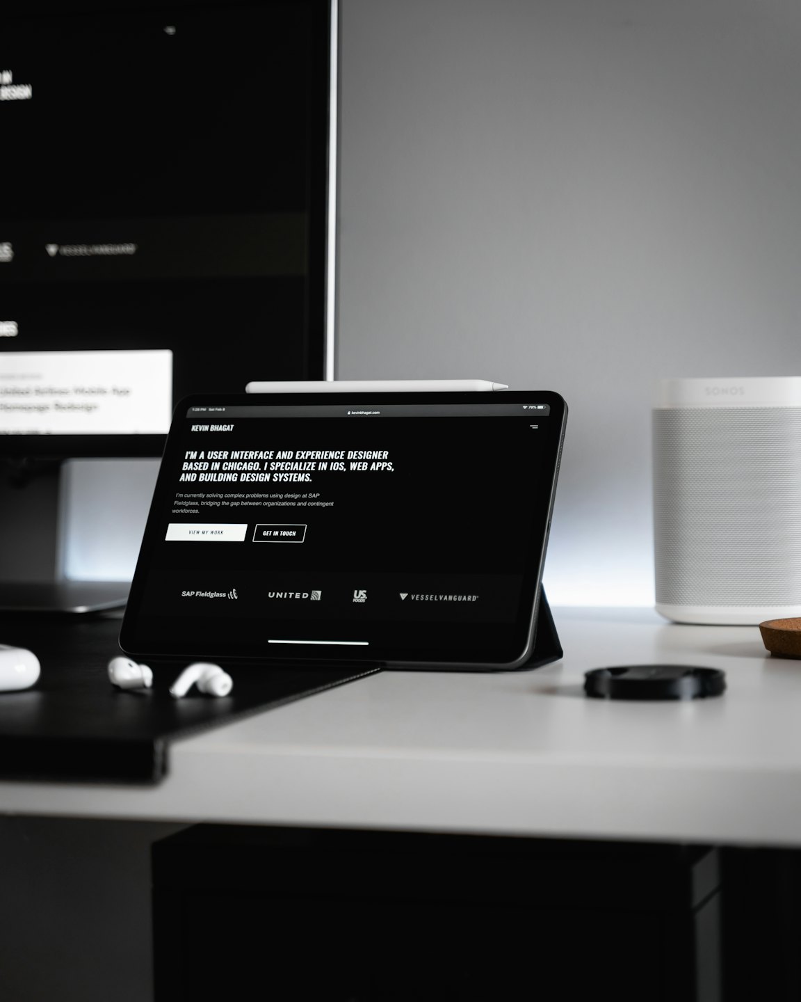 Tablet wyświetla stronę portfolio UI/UX na minimalistycznym biurku.